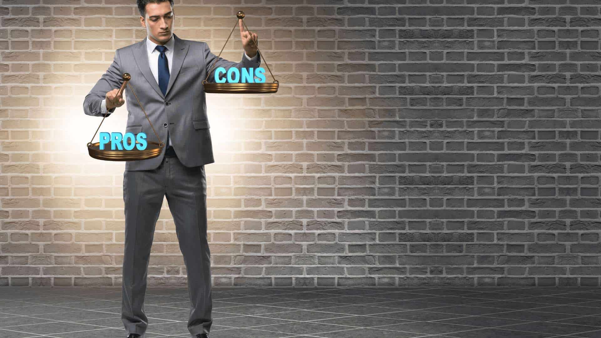 Mann in Anzug hält eine Waage mit den Wörtern 'PROS' und 'CONS' darauf.